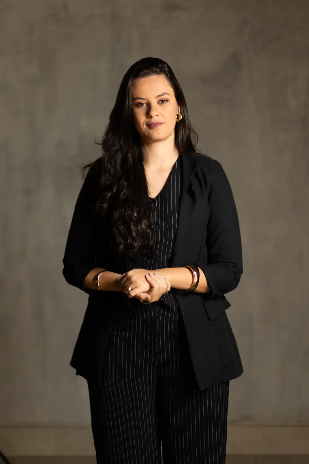 Retrato profissional de Raquel Lopes, de blazer preto
